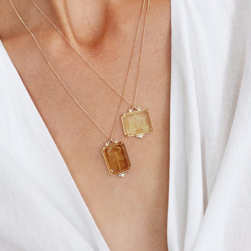 Close up of woman wearing new 14k intaglio zodiac necklaces